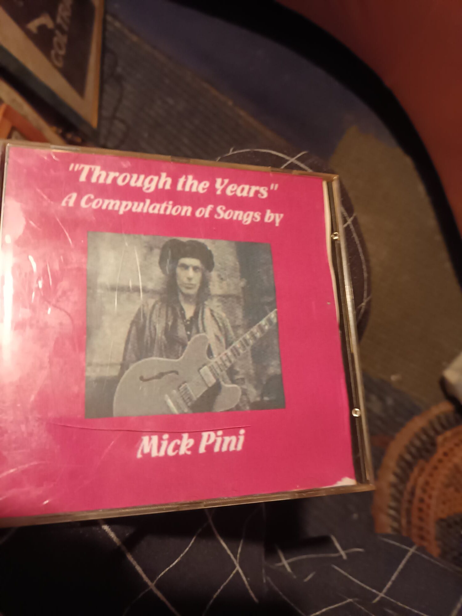 A Pink Cd Case With A Picture Of A Man Holding A Guitar